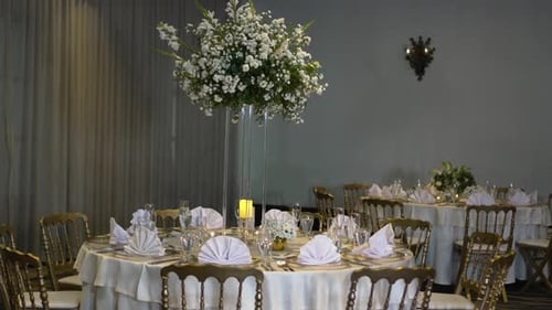 Round table decorated with a tall centerpiece of white Gypsophila paniculata flowers, in the hotel's