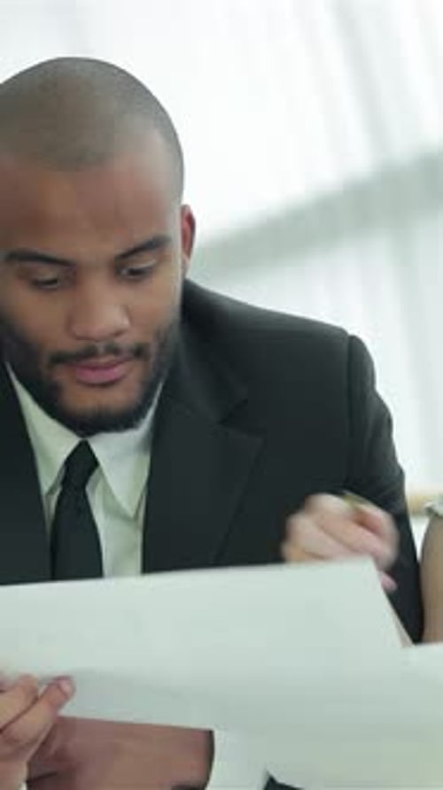 Dynamic Businessmen Engaged in Lively Discussion at Office Table