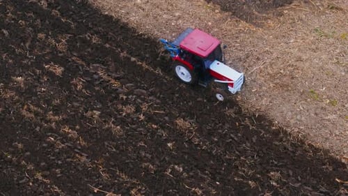 Farm Tractor Plowing Field
