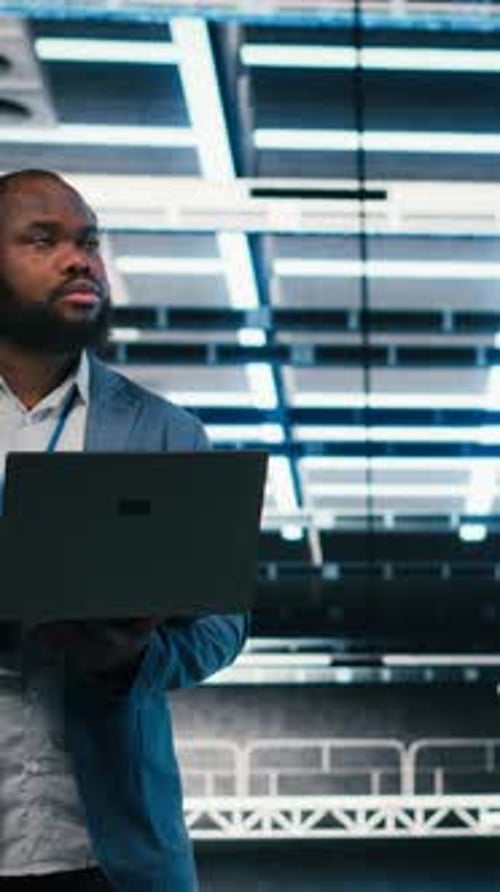 Vertical Video Team of Server Farm Software Developers Using Laptop to Optimize Electronics