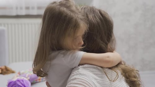 Trauriges kleines Mädchen umarmt ihre Mutter. Liebe zur Mutter.