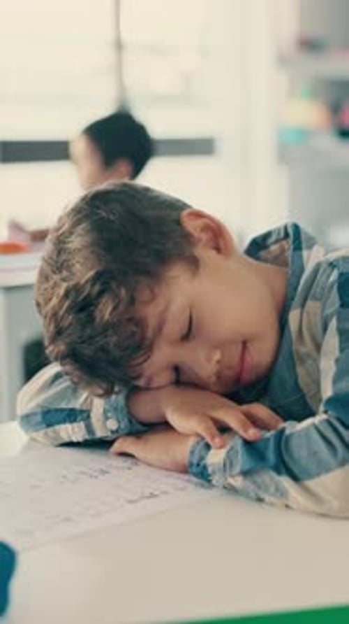 Tired, sleeping and kid in classroom at school with burnout for education, learning or knowledge