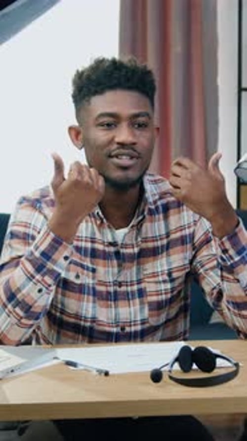 Young Man Talking and Gesturing at Desk