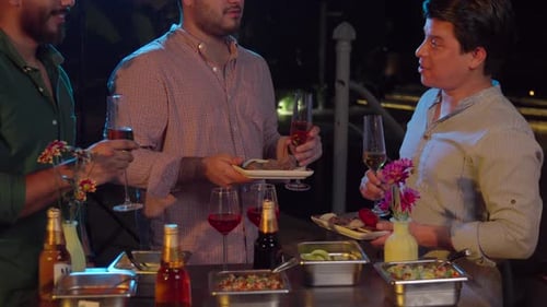 Latin mexican friends garden party barbecue grill receive meat steak sausage from waiter at night w