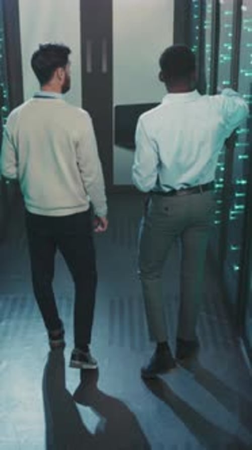 Men Walk Through Server Room Inspecting Data Racks