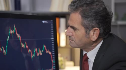 Mature trader man analyzing a stock market and cryptocurrency chart.