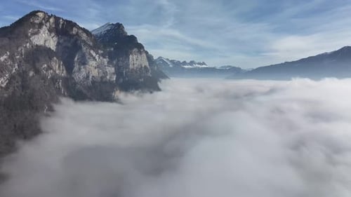 Majestic Cliffs Amidst Walensee Fog, Switzerland aerial above clouds