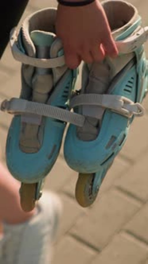 Junge Dame läuft mit blaugrünen Rollschuhen auf verschachteltem Pfad im Freien