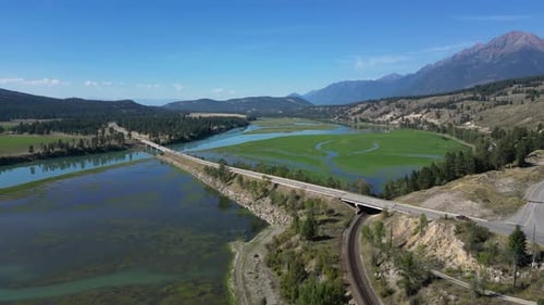 Luftaufnahme von Fluss, Autobahn und Eisenbahn im malerischen Tal, umgeben von Bergen