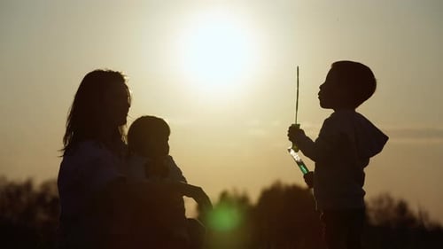 Family Fun Blowing Bubbles at Sunset