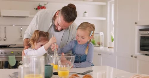 Father and Daughters Cooking Together in Kitchen