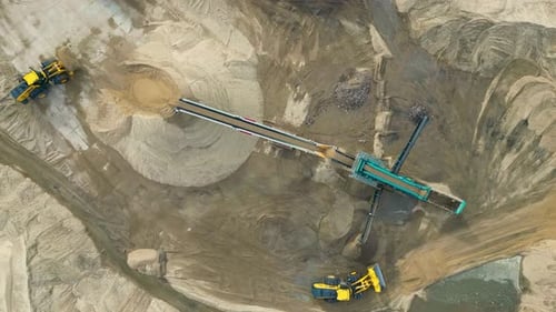 Wheel loader load sand in dump truck in open pit. Heavy machinery on developing opencast. Front end