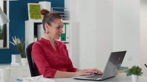 Woman Works on Laptop in Modern Office