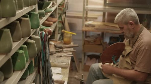 Senior Shoemaker Using Glue at Work in Cobbler Workshop