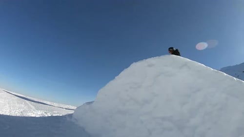 Snowboarder fährt ab, springt im Snowpark und macht an einem strahlend sonnigen Tag in Neuseeland einen 360-Grad-Indie-Schnappschuss