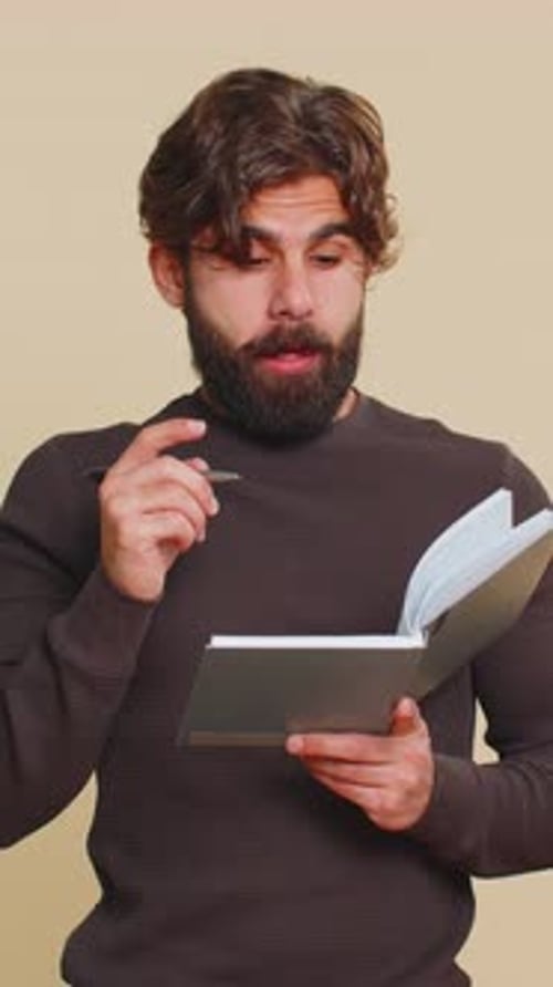 Man Writing in Notebook Thinking Hard