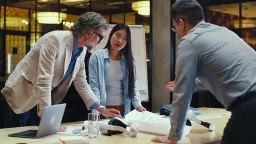 Team of Engineers Discussing Blueprint in Office Room