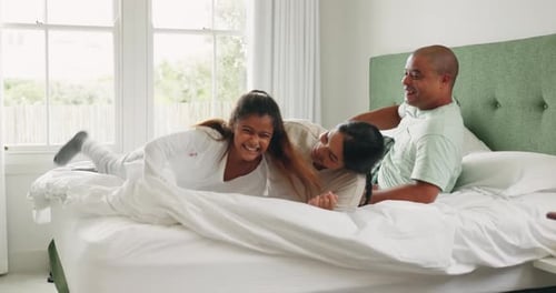 Happy Family Playing Together on Bed at Home