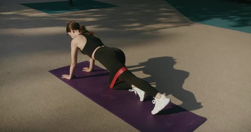 Athletic Woman Exercising Outdoors with Resistance Band