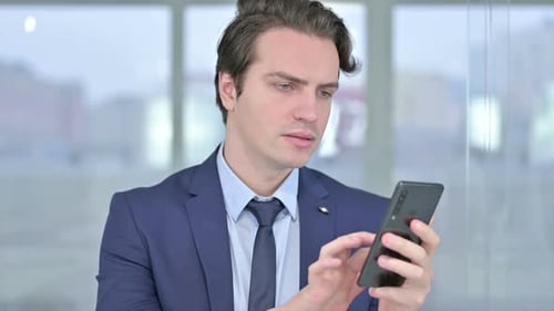 Man in Suit Using Smart Phone in Office