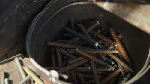 Metal Bars Dropped into a Metal Bucket