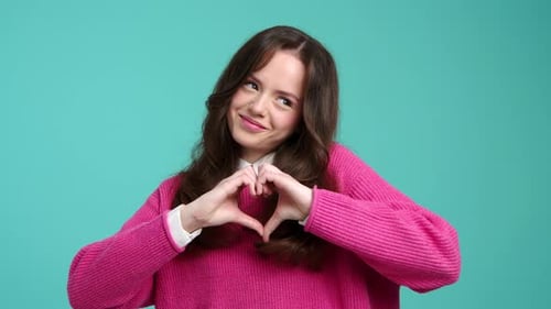 Smiling Girl Makes Heart Shape with Hands
