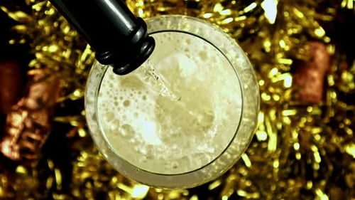 Sparkling Champagne Poured in Glass with Gold Tinsel