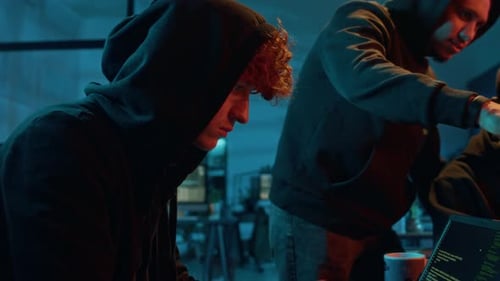 Young Male Fraudster Engaging in Illegal Activities Using Laptop