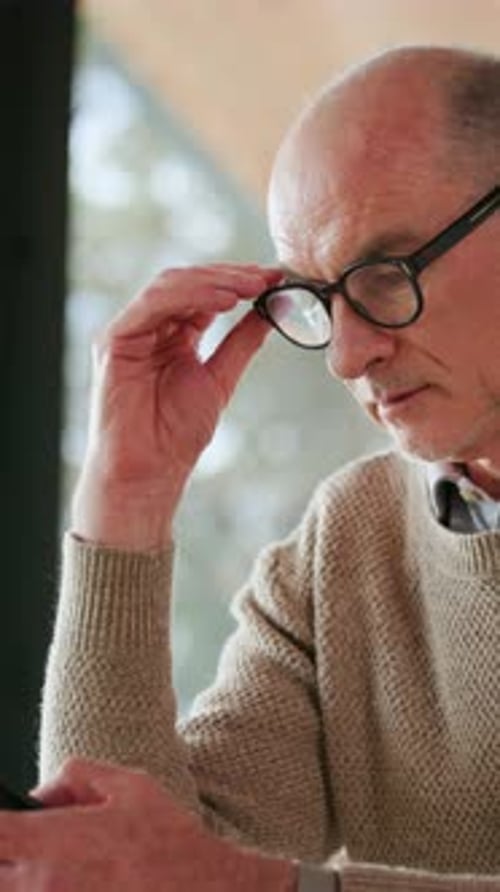 Senior Man With Glasses Using Mobile Phone