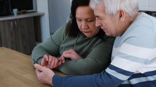 Senior Couple Using a Mobile Phone at Home