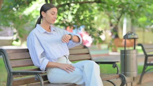 Woman Sitting on Bench Checking Her Watch