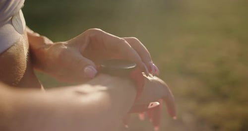 Woman Taps Smart Watch in Golden Light