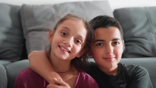 Smiling Girl and Boy Posing Closely Together Indoors