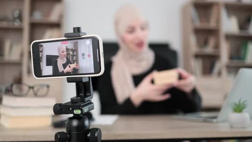 Focus on Phone of Muslim Woman in Casual Wear and Hijab Recording Video on Smartphone
