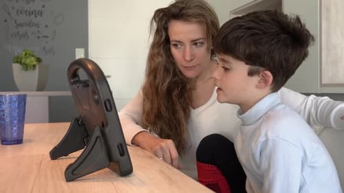 Woman and Child Using Tablet at Table