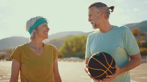 Active Senior Couple Talking with Basketball Outdoors