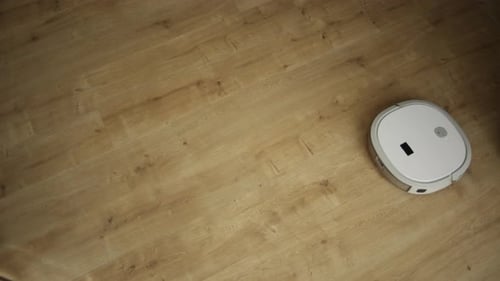 Top View of a Robot Vacuum Cleaner on Wooden Floor Cleaning
