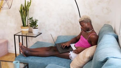 Young Adult Using Laptop While Relaxing on Couch
