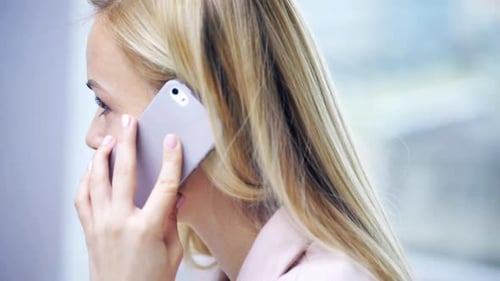 Woman in Business Suit Talking on Cell Phone