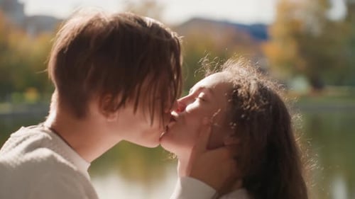 Young Couple Kisses Passionately in a Sunny Urban Park