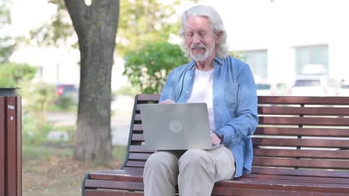 Senior Using Laptop for Video Call in Park