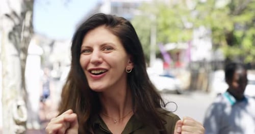 4k video footage of an attractive young woman cheering happily while out in the city