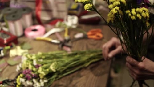 Florist making bouquet of flowers in flower shop in Lviv