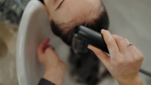 Woman Receiving Shampoo and Scalp Massage at Salon
