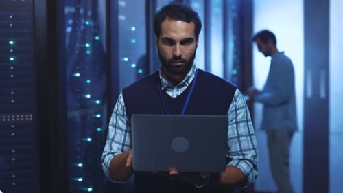 Eine fokussierte Person in einem Serverraum präsentiert technisches Fachwissen