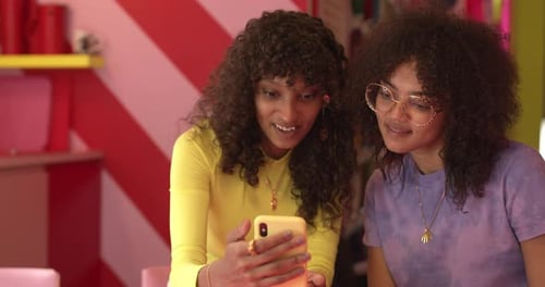 Two Young Women Looking at Smartphone Together