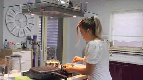 Woman Cooking Meal in Modern Kitchen Stirring Pot