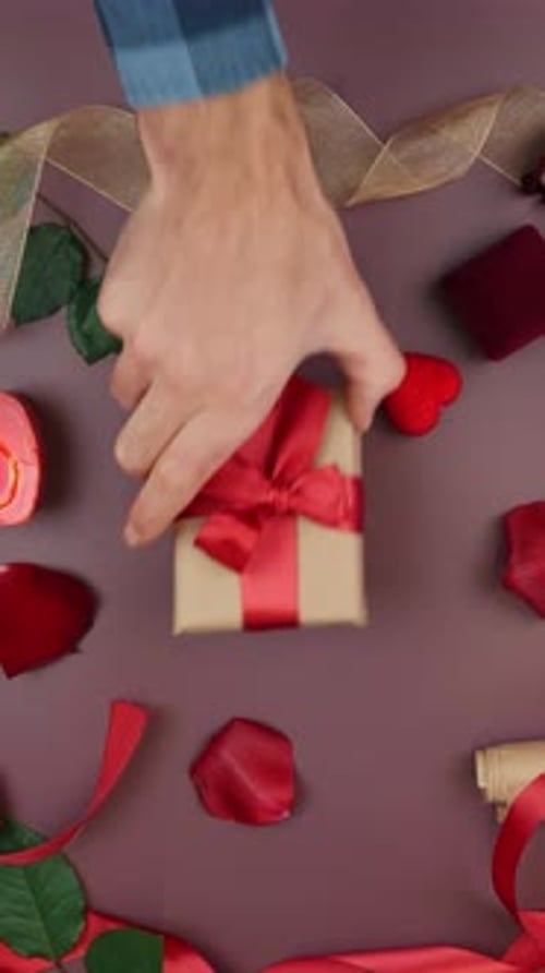 Woman gives present box to man for St. Valentine's Day. Vertical video