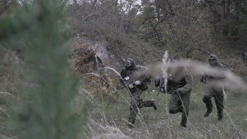 Hier rennen Männer von Paintballspielern in Zeitlupe im Wald