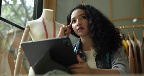 Woman Designs Fashion with Tablet and Stylus